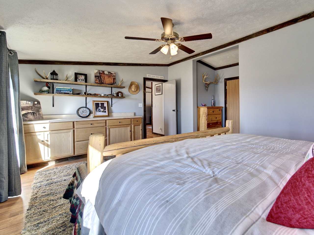 1675 North 1/2 Road Fruita, CO 81521 - Photo 14 of 31 a spacious bedroom with a bed and a chandelier