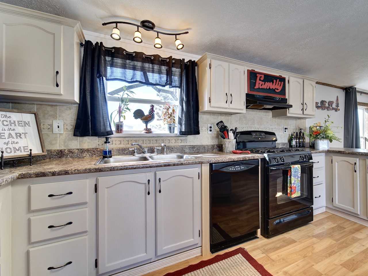 1675 North 1/2 Road Fruita, CO 81521 - Photo 3 of 31 a kitchen with granite countertop a sink cabinets stainless steel appliances and a window