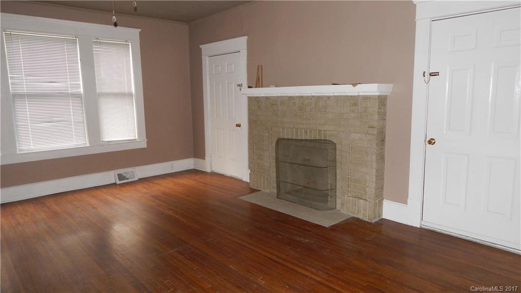 203 Charles Street, Unit A Monroe, NC 28112 - Photo 2 of 10 an empty room with wooden floor cabinet and windows