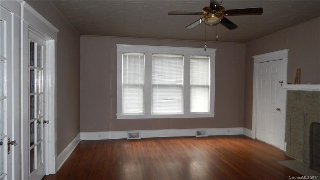 203 Charles Street, Unit A Monroe, NC 28112 - Photo 6 of 10 an empty room with wooden floor fan and windows
