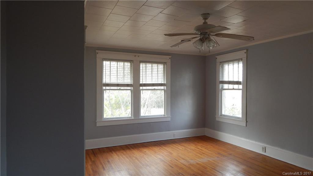 203 Charles Street, Unit A Monroe, NC 28112 - Photo 9 of 10 an empty room with a window and wooden floor