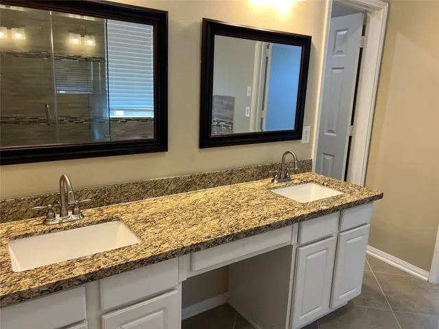 a bathroom with a granite countertop sink and a mirror