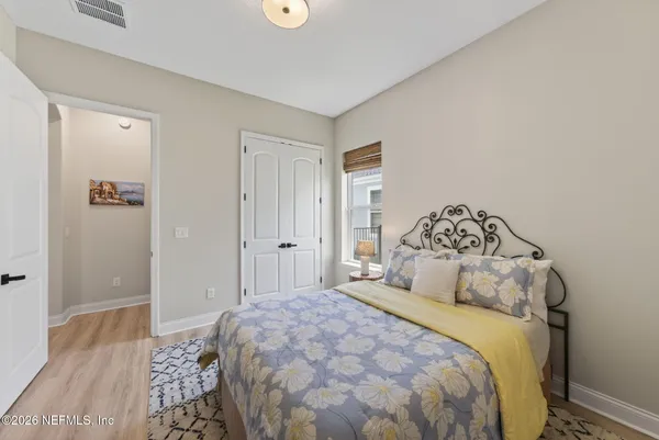 a spacious bedroom with a bed and a flat screen tv