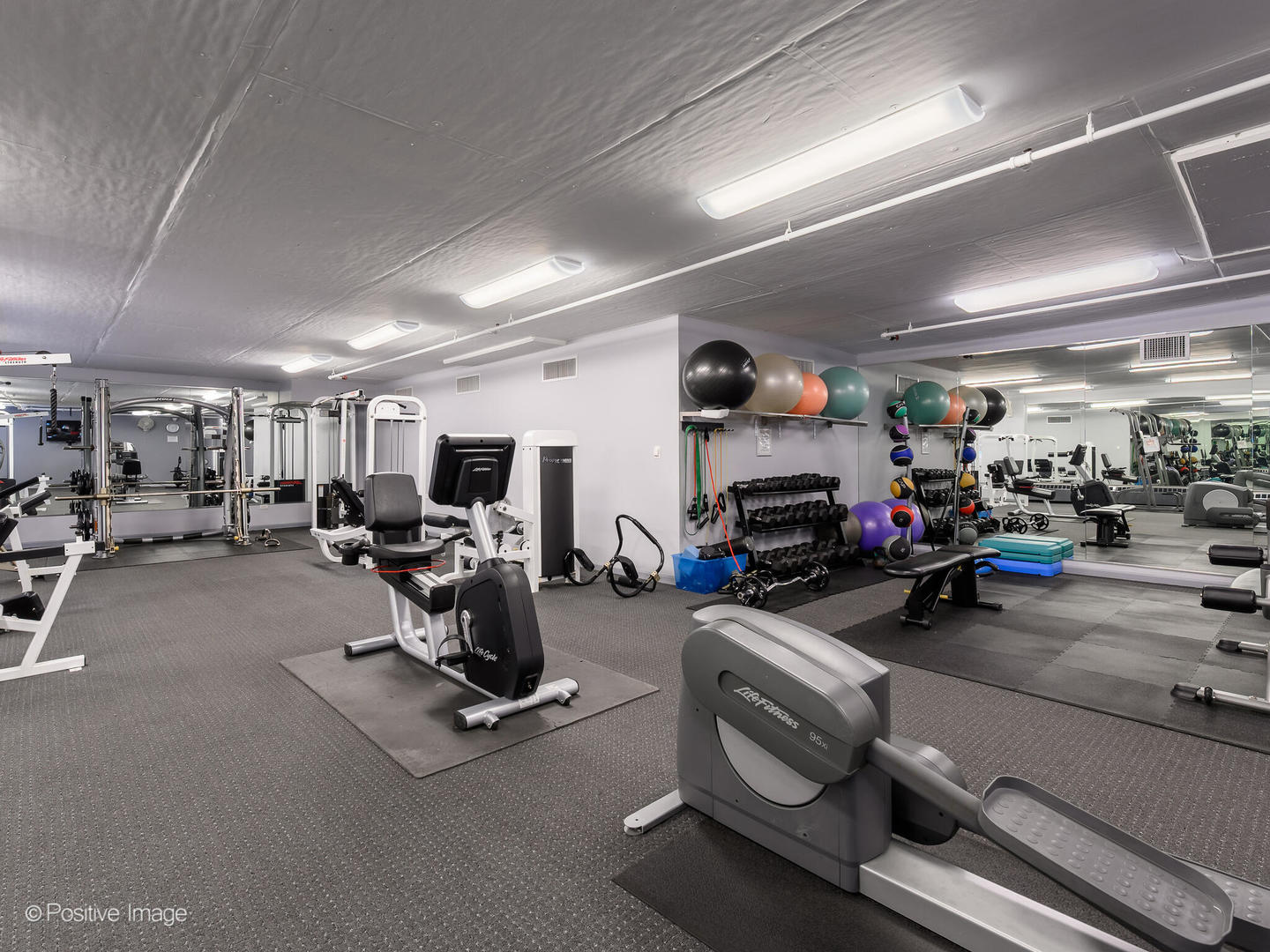 21 West Chestnut Street, Unit 1202 Chicago, IL 60654 - Photo 27 of 29 a room with gym equipment and a mirror