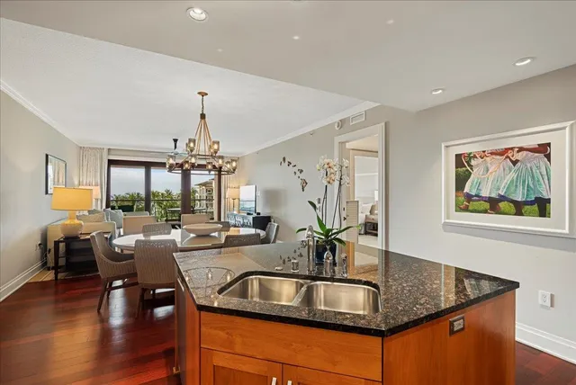 a kitchen with granite countertop a sink dining table and chairs