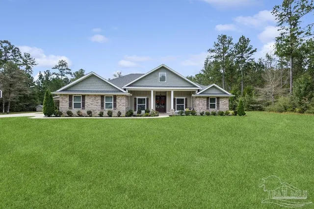 a aerial view of a house with a big yard and large trees