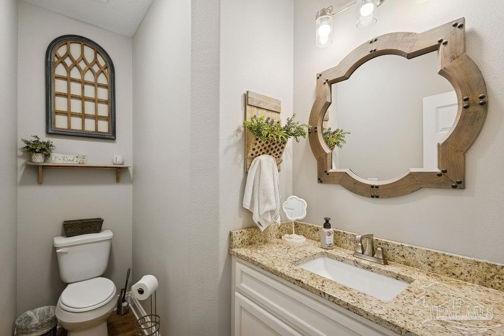 1571 Annie Penton Road Jay, FL 32565 - Photo 35 of 46 a bathroom with a granite countertop toilet sink and mirror