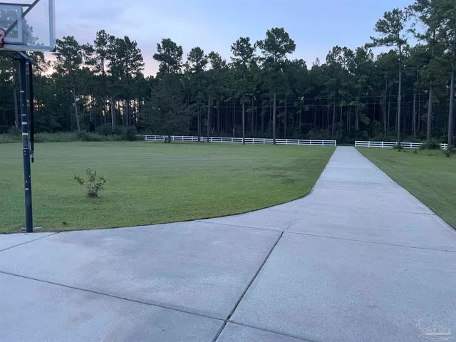 a front view of a house with garden and trees
