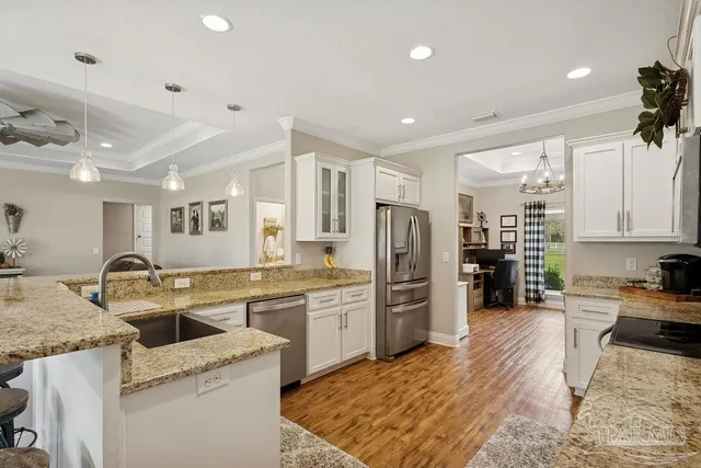 a spacious bedroom with a large bed and a chandelier