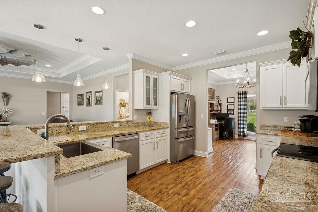 1571 Annie Penton Road Jay, FL 32565 - Photo 5 of 46 a kitchen with a refrigerator a sink a stove a oven with cabinets and wooden floor