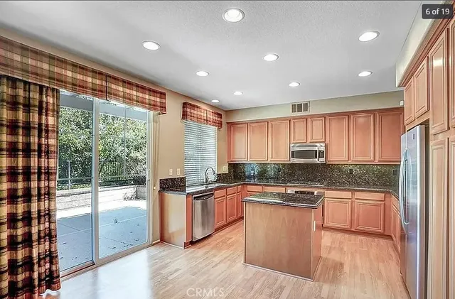 a kitchen with stainless steel appliances granite countertop a stove a sink and a refrigerator