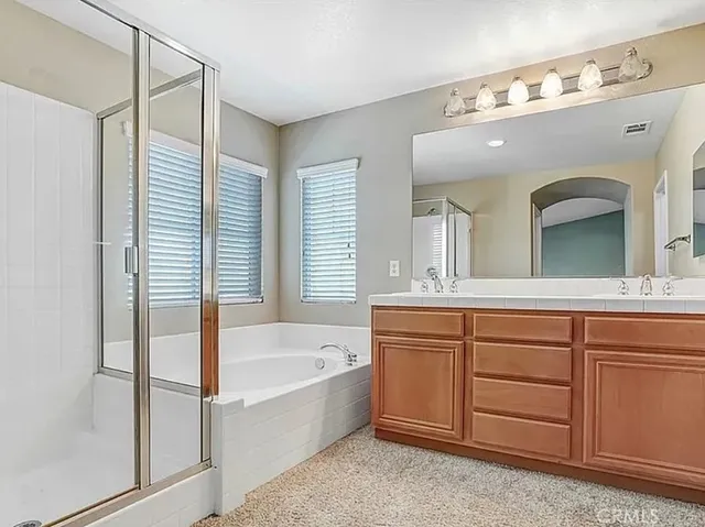 a bathroom with a tub sink and mirror