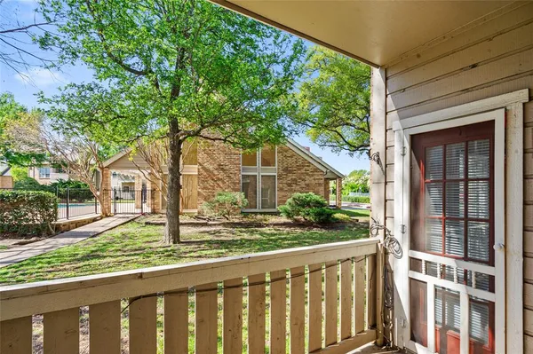 a porch with a tree in front of it