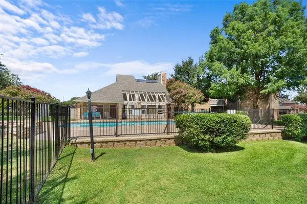 a view of a house with a yard and a large tree