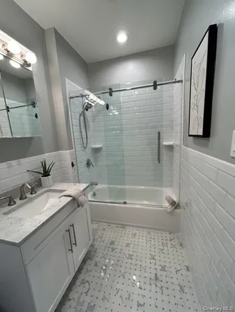 a bathroom with a tub a sink and a mirror