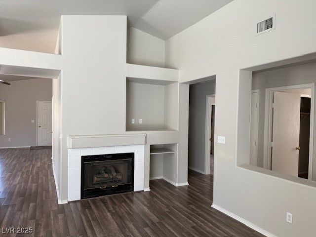 951 Country Back Road Las Vegas, NV 89123 - Photo 12 of 20 Unfurnished living room featuring wood finished floors, vaulted ceiling, baseboards, and a tile fireplace