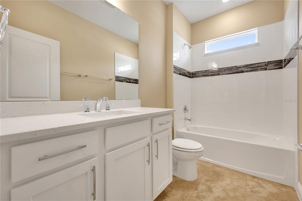 2132 Keystone Pass Boulevard Minneola, FL 34715 - Photo 14 of 52 a bathroom with a sink a toilet and a large mirror