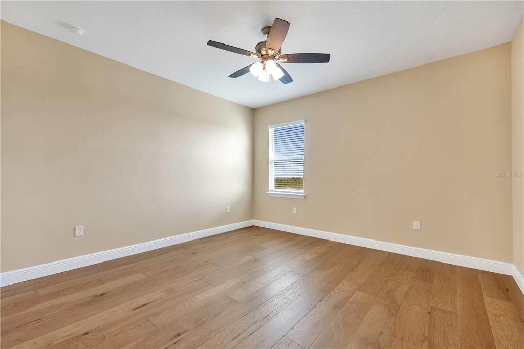 2132 Keystone Pass Boulevard Minneola, FL 34715 - Photo 20 of 52 a view of a room with wooden floor and a ceiling fan