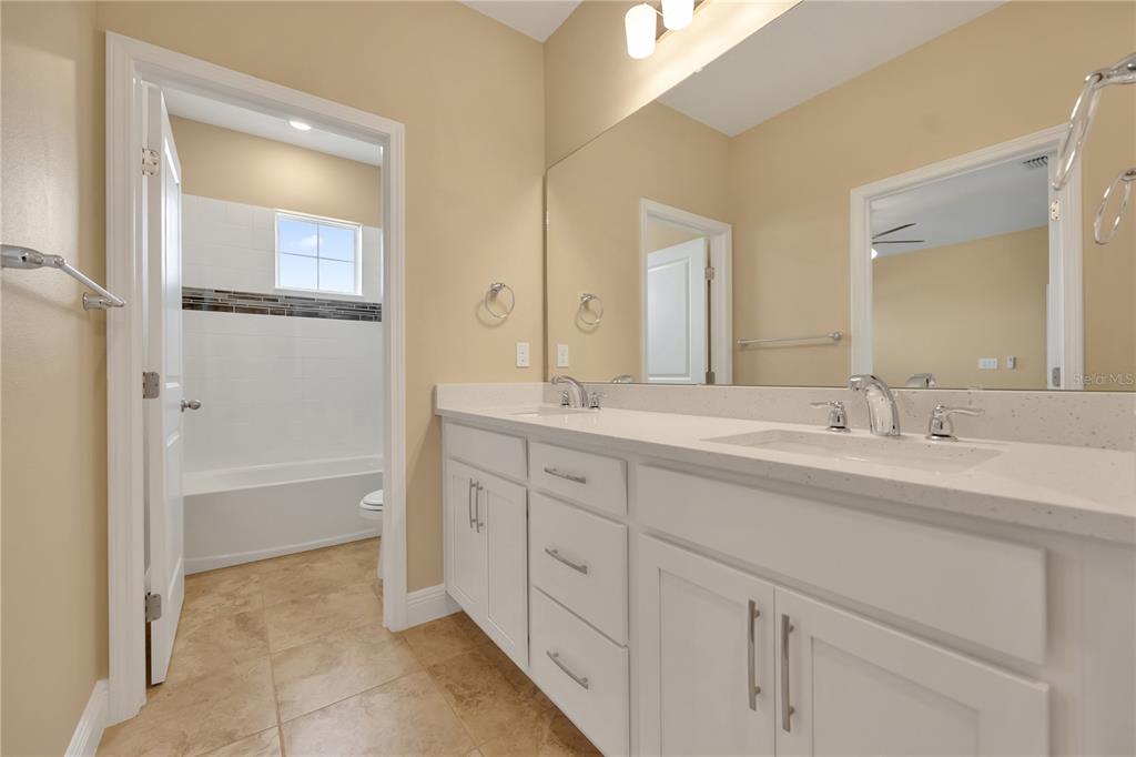 2132 Keystone Pass Boulevard Minneola, FL 34715 - Photo 25 of 52 a bathroom with a granite countertop sink mirror and a bathtub