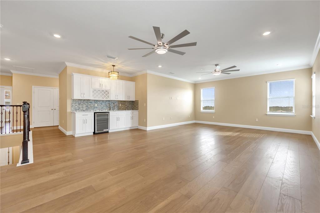 2132 Keystone Pass Boulevard Minneola, FL 34715 - Photo 30 of 52 an empty room with wooden floor fireplace and windows