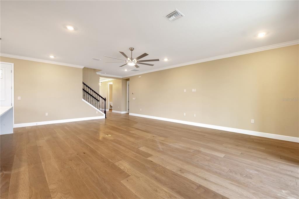 2132 Keystone Pass Boulevard Minneola, FL 34715 - Photo 3 of 52 a view of an empty room with wooden floor and a ceiling fan