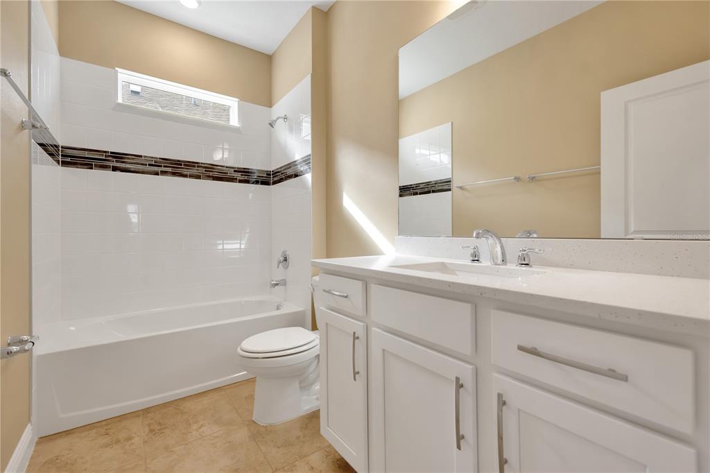2132 Keystone Pass Boulevard Minneola, FL 34715 - Photo 33 of 52 a bathroom with a sink a toilet and a large mirror