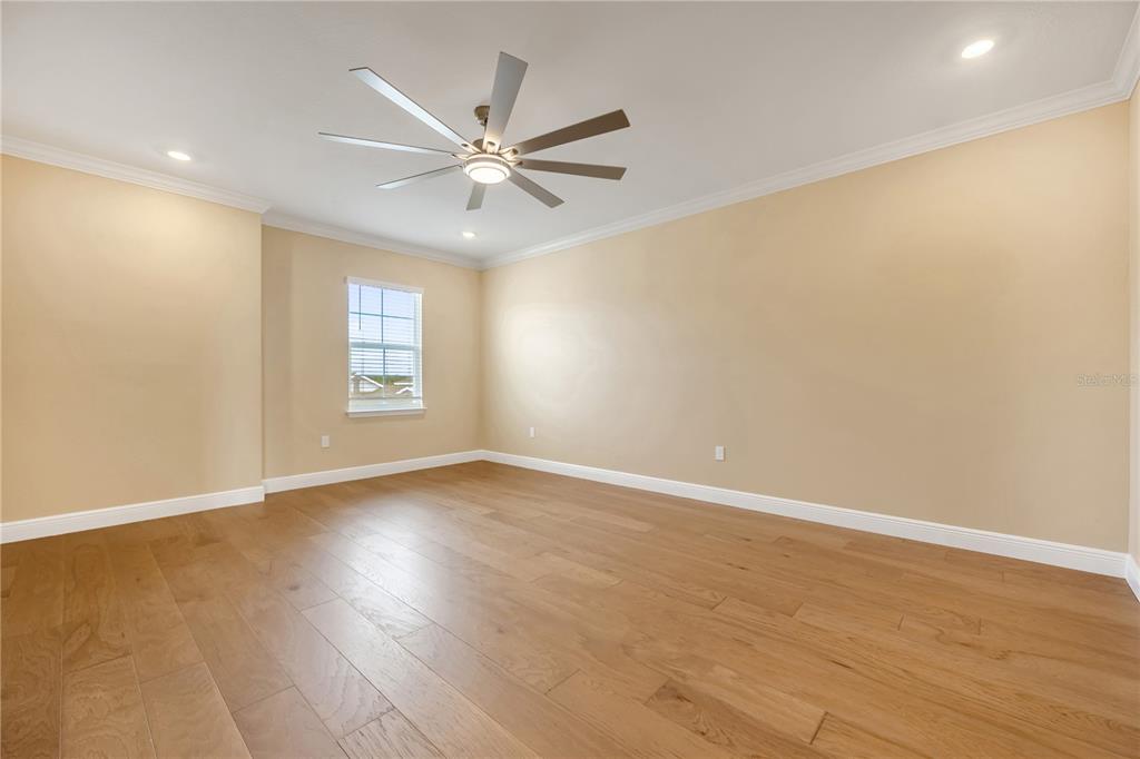 2132 Keystone Pass Boulevard Minneola, FL 34715 - Photo 34 of 52 an empty room with wooden floor fan and windows