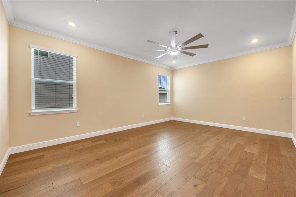 2132 Keystone Pass Boulevard Minneola, FL 34715 - Photo 42 of 52 an empty room with wooden floor fan and windows