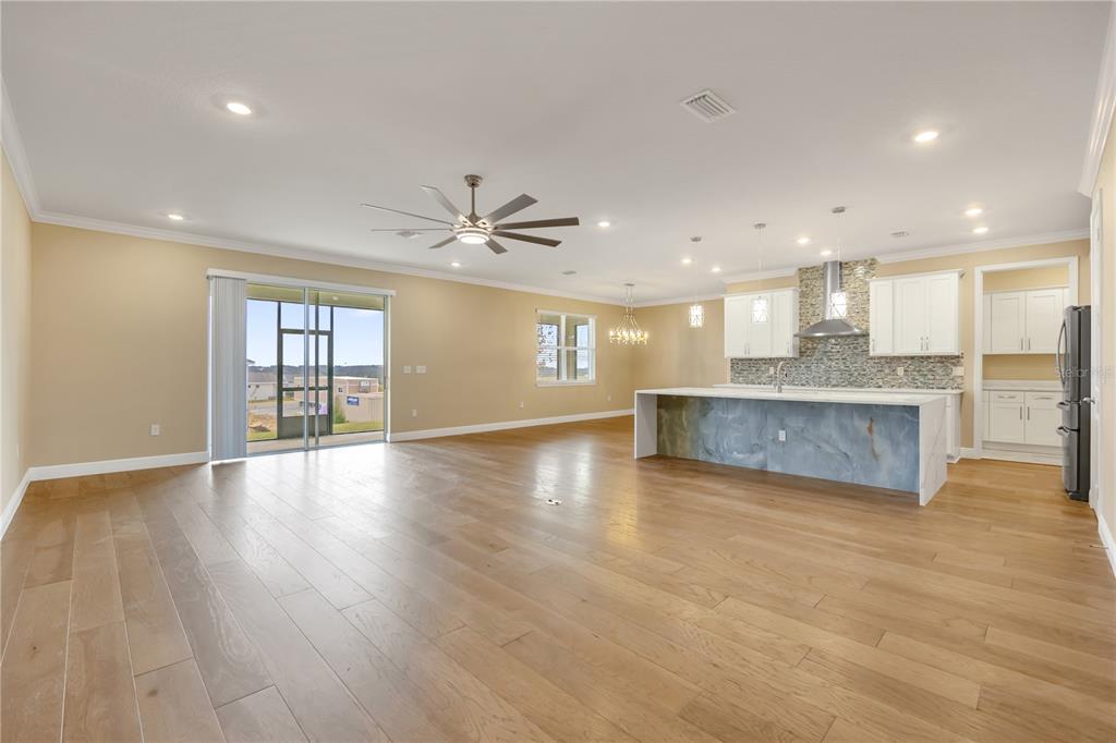 2132 Keystone Pass Boulevard Minneola, FL 34715 - Photo 5 of 52 an empty room with wooden floor and windows