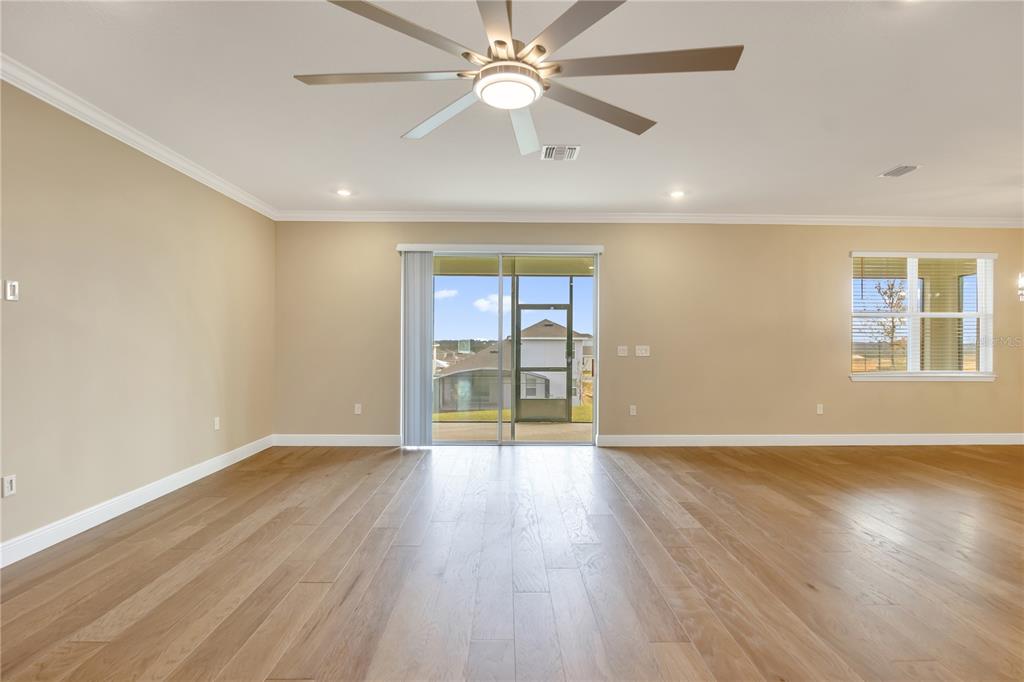 2132 Keystone Pass Boulevard Minneola, FL 34715 - Photo 6 of 52 wooden floor in an empty room with a window