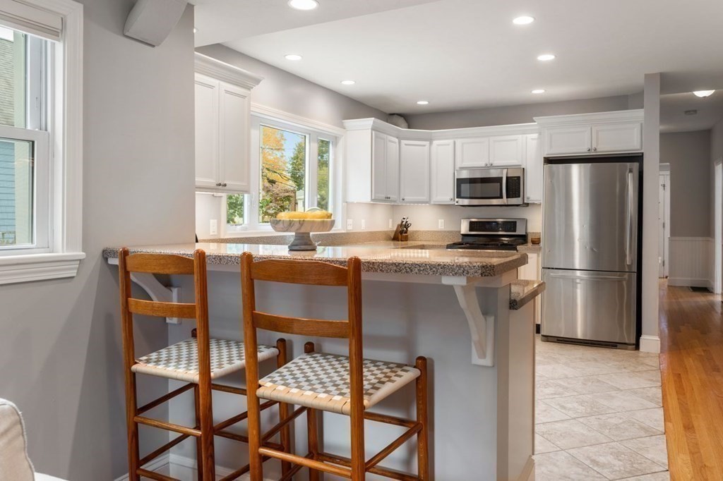 6 Willow Street Natick, MA 01760 - Photo 18 of 32 a kitchen with stainless steel appliances granite countertop a stove a refrigerator a microwave a sink and a island