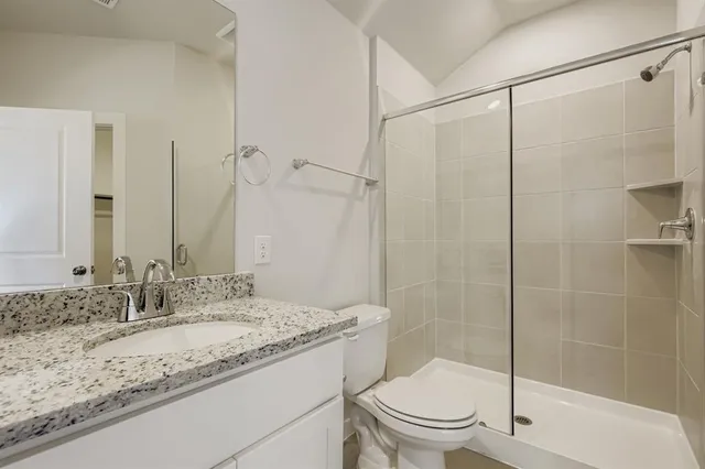 a bathroom with a granite countertop sink toilet and shower