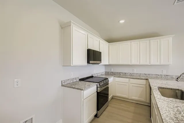 a kitchen with a sink stove and microwave