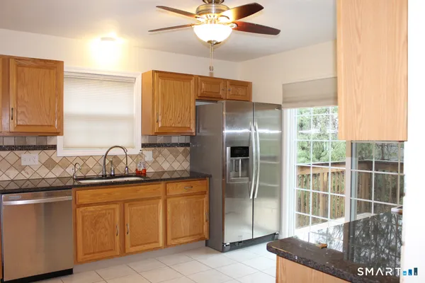 a kitchen with stainless steel appliances granite countertop a sink and a refrigerator