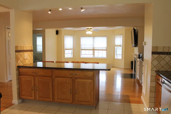 a spacious bathroom with a granite countertop sink a mirror and a bathtub