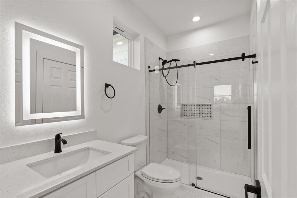 504 South Tennessee Street McKinney, TX 75069 - Photo 31 of 40 Full bathroom with vanity, a stall shower, and a textured wall