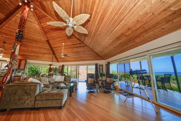 a room with lots of wooden furniture lots of wooden furniture and large windows