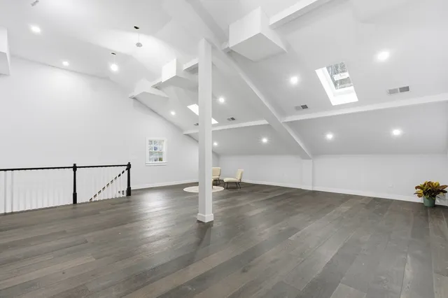 an empty room with wooden floor and natural light