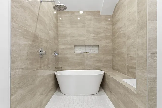 a white bath tub sitting in a bathroom and a shower