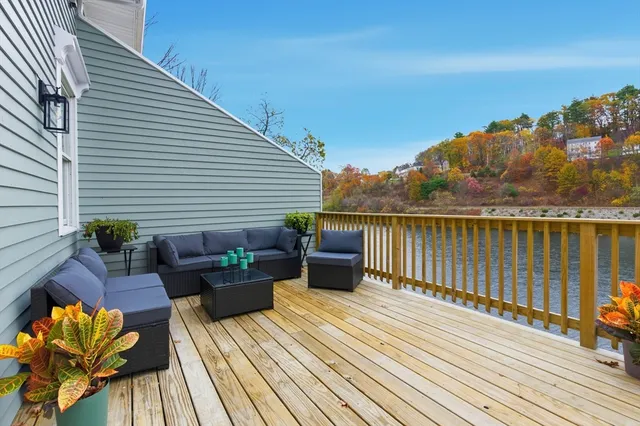 a balcony with wooden floor table and chairs
