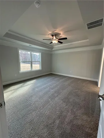 an empty room with windows and fan