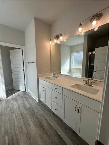 a spacious bathroom with double vanity and a mirror