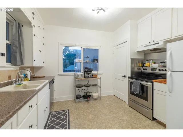 a kitchen with a sink stove and white cabinets