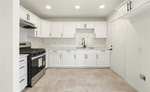 a kitchen with granite countertop white cabinets and white appliances
