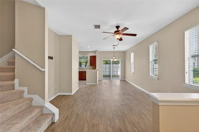 a view of a livingroom with wooden floor and a ceiling fan