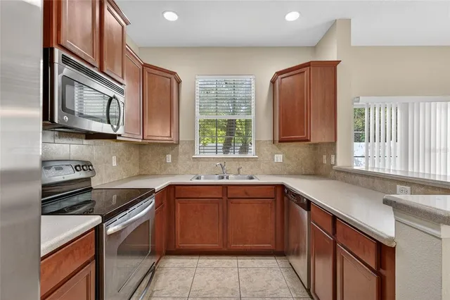 a kitchen with stainless steel appliances granite countertop a sink stove and microwave