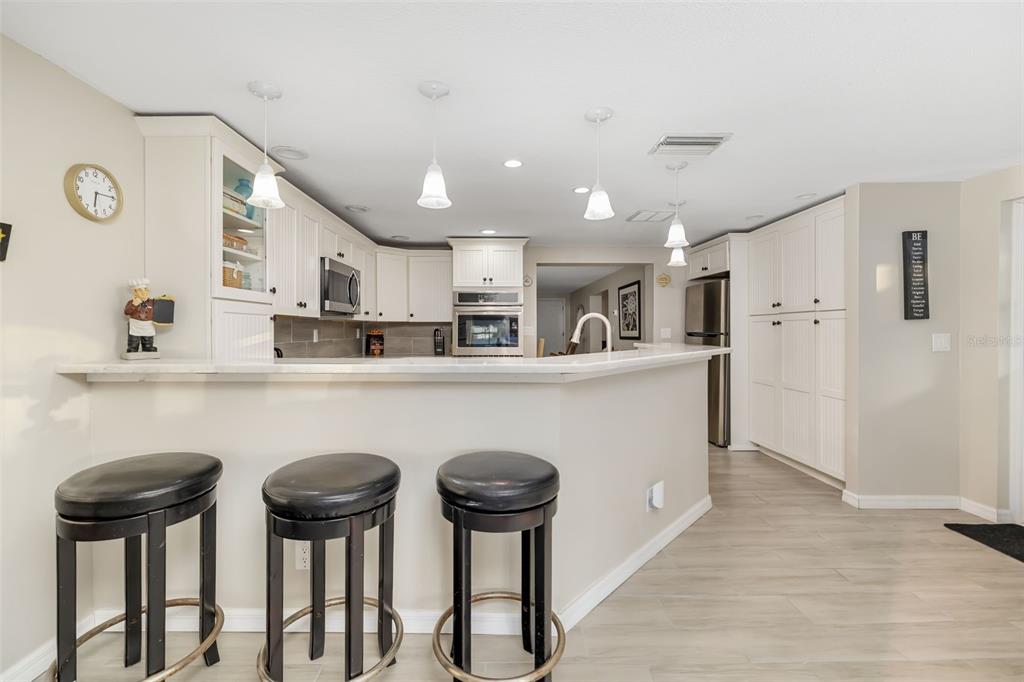 410 Pameto Road Nokomis, FL 34275 - Photo 15 of 40 a kitchen with stainless steel appliances a refrigerator a stove a sink dishwasher with wooden cabinets and chair