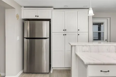 a kitchen with granite countertop white cabinets and stainless steel appliances