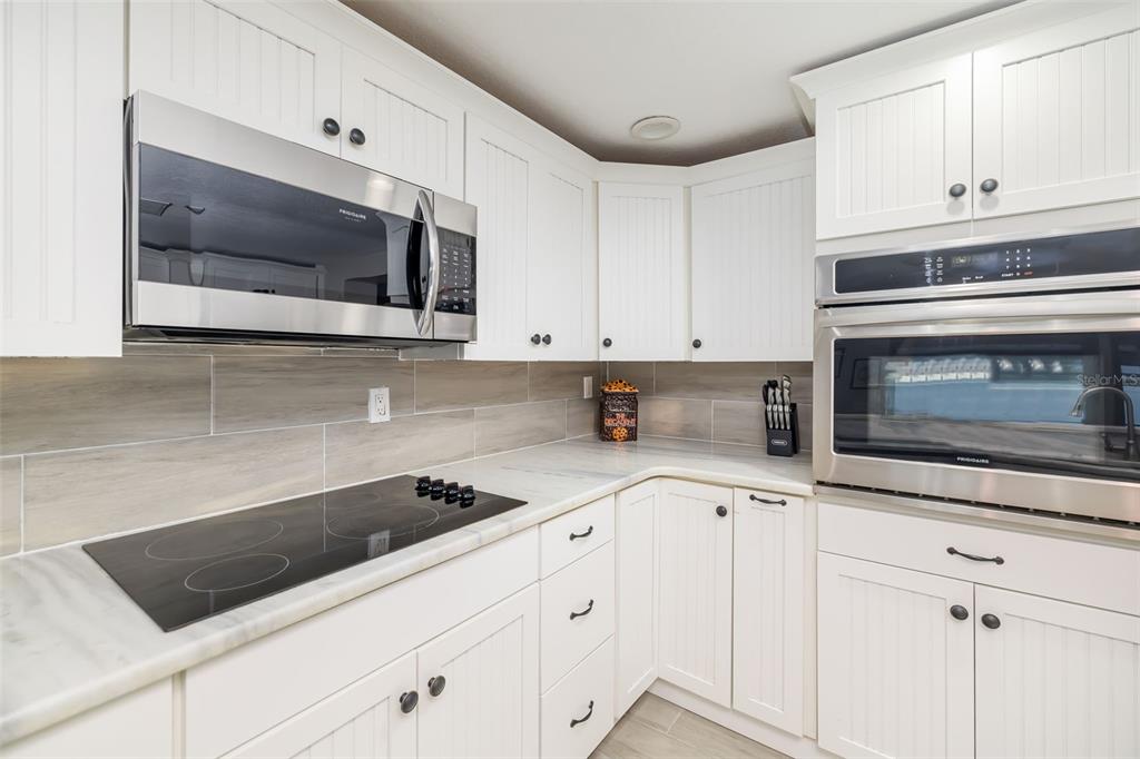 410 Pameto Road Nokomis, FL 34275 - Photo 19 of 40 a kitchen with granite countertop white cabinets and stainless steel appliances
