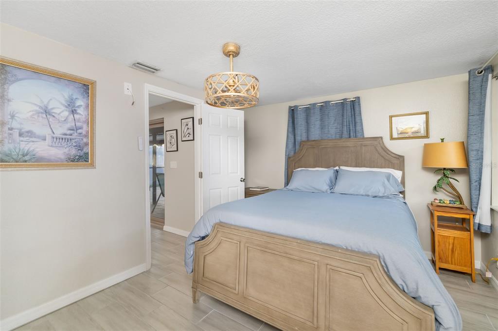 410 Pameto Road Nokomis, FL 34275 - Photo 25 of 40 a bedroom with a bed and a chandelier